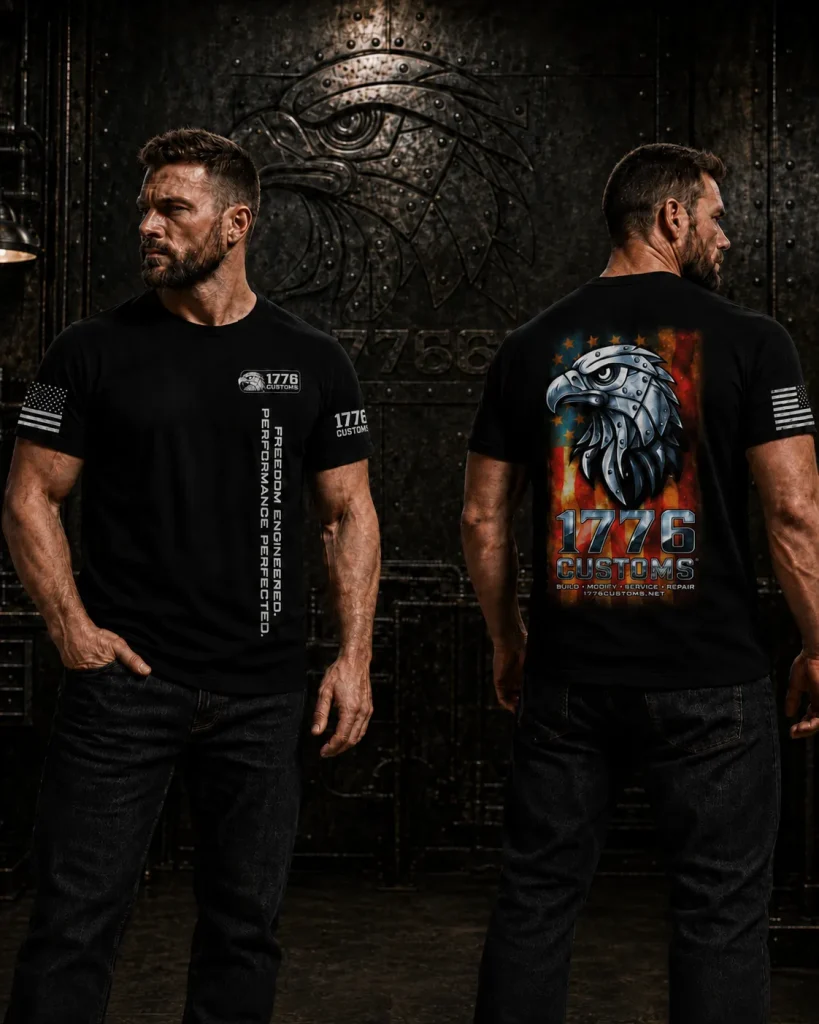 Front and back view of a male model wearing the black 1776 Customs Patriot Eagle T-Shirt, showcasing vertical chest text on the front and a large patriotic American flag with a mechanical eagle head graphic on the back.