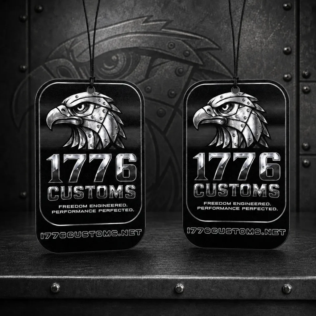 1776 Customs automotive hanging car air freshener featuring metallic eagle head graphic, chrome block logo, and slogan.