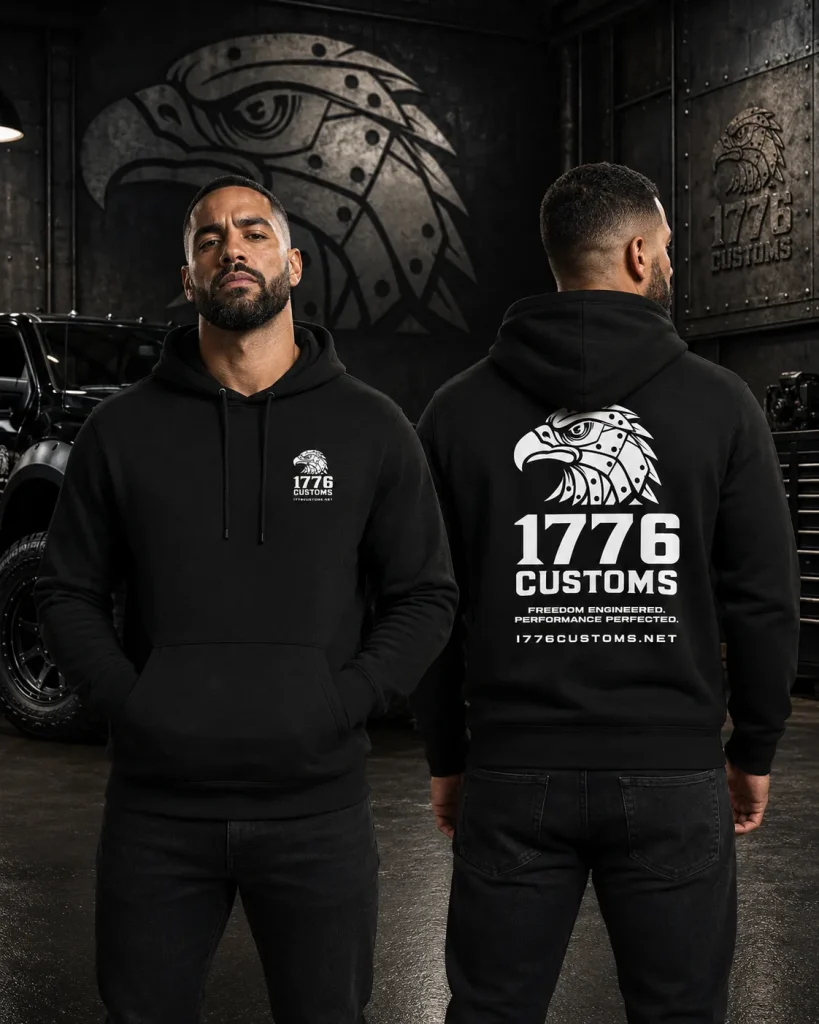 Front and back view of a model wearing a black 1776 Customs pullover hoodie featuring a small chest logo and large back eagle graphics.